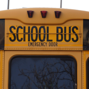 Back of a school bus focused on the words "School Bus" and "Emergency door"